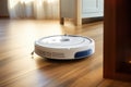 Robotic vacuum cleaner on laminate wood floor. Modern smart cleaning technology