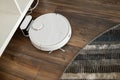 Robotic vacuum cleaner on laminate wood floor smart cleaning technology Royalty Free Stock Photo