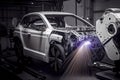 Robotic welder in automotive industry, white robot welding car body in car factory