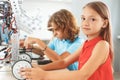 Robotics. Children sitting having class making robots girl close-up looking camera curious