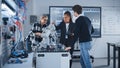 In Robotics Development Laboratory: Black Female Teacher and Two Students Work With Prototype of