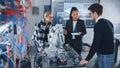 In Robotics Development Laboratory: Black Female Teacher and Two Students Work With Prototype of