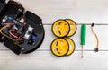 robotics parts. four-wheel drive, a screwdriver lying on a wooden table. view from above