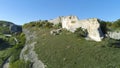 Rock above gorge. Shot. Top view of landscape of stone ridge hills, blue sky and green gorge. Sunny day in mountain