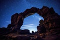 rock arch silhouetting against a star-studded night sky Royalty Free Stock Photo