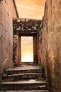 Rock Architecture Narrow ancient old street with stone steps to an open rock door with an open sky sunset Royalty Free Stock Photo