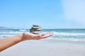 Rock balance, hand and beach for meditation, yoga or peace exercise in nature by water, Hands holding rocks for chakra Royalty Free Stock Photo