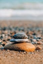 Rock Balancing On Ocean Beach. Pyramid Of Pebbles On Sandy Shore. Stable Pile Or Heap In Soft Focus With Bokeh, Close Up