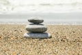 Rock Balancing On Ocean Beach. Pyramid Of Pebbles On Sandy Shore. Stable Pile Or Heap In Soft Focus With Bokeh, Close Up