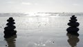 Rock balancing on ocean beach, stones stacking by sea water waves. Pyramid of pebbles on sandy shore