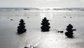 Rock balancing on ocean beach, stones stacking by sea water waves. Pyramid of pebbles on sandy shore