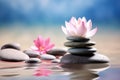 Rock balancing. Zen stacking stones piled in balanced in water with pink lotus flower Royalty Free Stock Photo