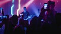 Rock Band with Guitarists and Drummer Performing at a Concert in a Night Club. Front Row Crowd is Royalty Free Stock Photo