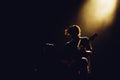 Rock band performs on stage. Guitarist plays solo. silhouette of guitar player in action on stage in front of concert crowd. Close Royalty Free Stock Photo