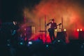 Rock band performs on stage. Guitarist plays solo. silhouette of guitar player in action on stage in front of concert crowd. Royalty Free Stock Photo