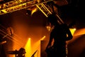 Rock band performs on stage. Guitarist plays solo. silhouette of guitar player in action on stage in front of concert crowd.