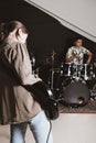 rock band rehearsal in a studio. female bass guitarist and teen male drummer performing a song. vertical size