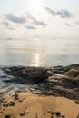 Rock on the beach with calm sea during sunrise in dawn Royalty Free Stock Photo