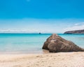 Rock at the beach of an island in Mexico with clear water and boat on the background Royalty Free Stock Photo