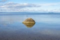 Rock in blue autumn lake in solitude Royalty Free Stock Photo