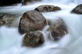 Rock boulders in flowing river waters Royalty Free Stock Photo