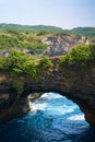 Rock broken by an ocean wave forming an arch in the mountain. Cliff is washed by powerful waves of ocean Royalty Free Stock Photo