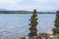 Rock cairn the art of stone balancing on a stone near a blue water flowing lake.