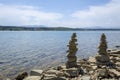 Rock cairn the art of stone balancing on a stone near a blue water flowing lake.