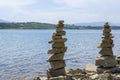 Rock cairn the art of stone balancing on a stone near a blue water flowing lake.