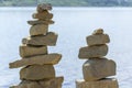 Rock cairn the art of stone balancing on a stone near a blue water flowing lake.