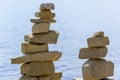 Rock cairn the art of stone balancing on a stone near a blue water flowing lake.