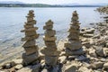 Rock cairn the art of stone balancing on a stone near a blue water flowing lake.