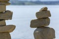 Rock cairn the art of stone balancing on a stone near a blue water flowing lake.