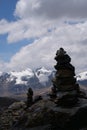 Rock cairns with the white snow capped mountain peaks of the Cordillera Blanca Andes mountain range in the background. Location: Royalty Free Stock Photo