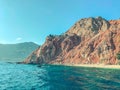 Rock in the center of the sea. blue water with bubbling foam with a large, high mountain in the center. rock formation in a warm Royalty Free Stock Photo