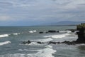 Rock cliffs in the Indian Ocean off the coast of Bali island, near Batu Bolong and tourism attraction spot Tanah Lot temple. Waves Royalty Free Stock Photo