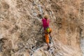 Rock climber girl leaging climbing route on natural rock