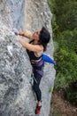 Rock climber girl climbing a rock with a dinosaur tail