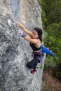 Rock climber girl climbing a rock with a dinosaur tail