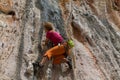 Rock climber girl in orange pants leaging climbing route on natural rock Royalty Free Stock Photo