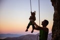 Rock climber giving a swing to his little daughter Royalty Free Stock Photo