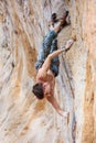 Rock climber gripping a chipped off piece of cliff while climbing a natural cliff