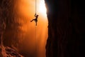 rock climber hangs on a rope in a deep abyss, the sunlight filtering through the rocks as they display their strength