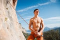 Rock climber holding belay rope over the mountains