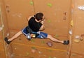 Rock Climber holding splits while climbing brown wall