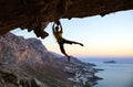 Rock climber jumping on handholds while climbing cliff