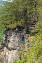 Rock climber looks small against a huge cliff in the New River Gorge