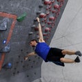 Rock Climber performing flagpole on bouldering wall