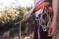 A rock climber prepares equipment for climbing, woman holds a rope, knot