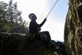 Rock climber sitting on a ledge while supporting his teammate in Torrelodones, Madrid. Extreme sports